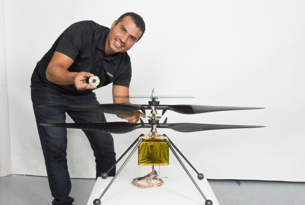 Loay Elbasyouni beside the Ingenuity Mars Helicopter.
